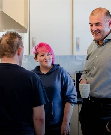 people chatting in a kitchen.