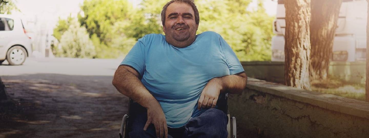  disabled man smiling sat in his wheelchair.