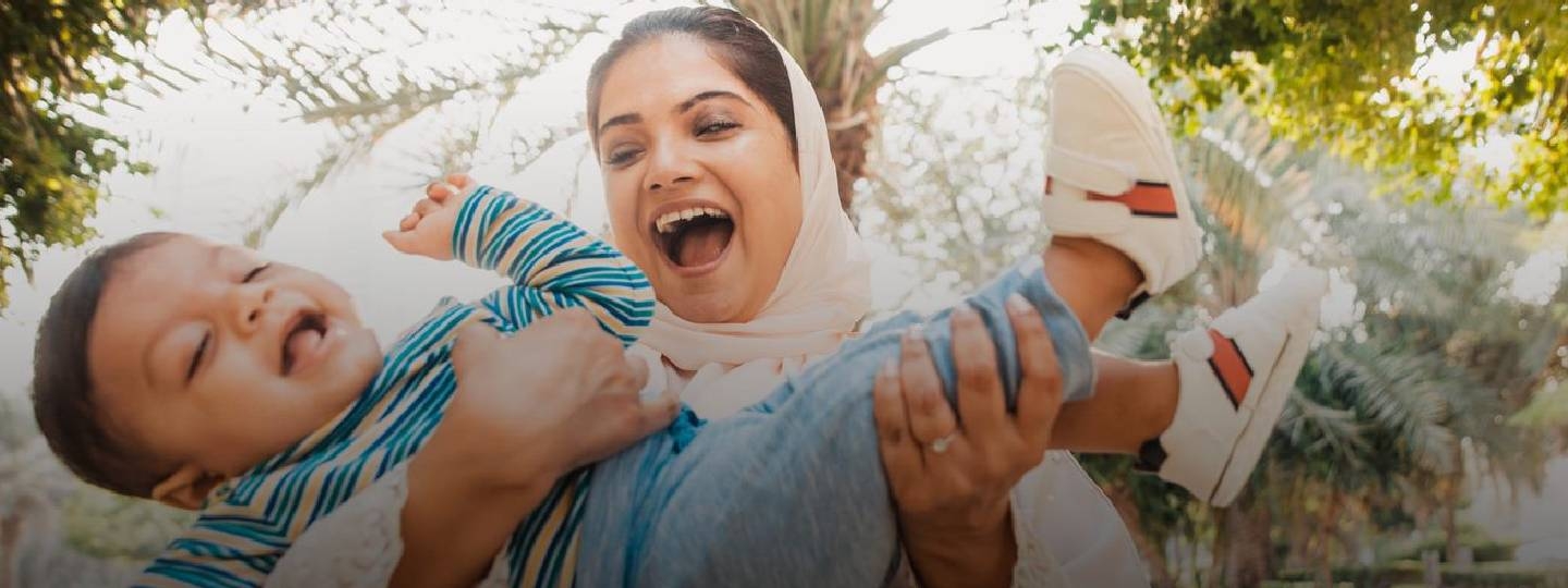 mother playing with her child and both are laughing.