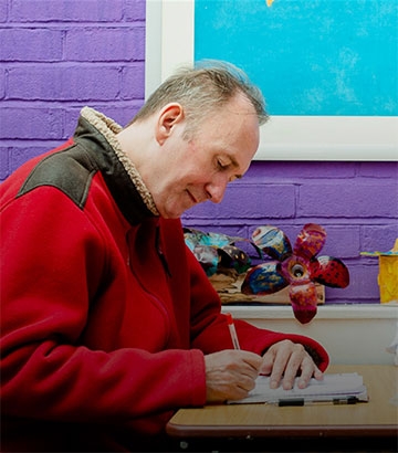 man sat at table working.