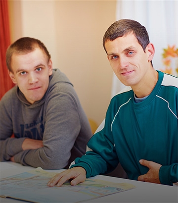 two young men smiling at the camera.