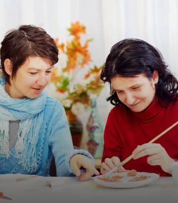 two women happily painting pictures.