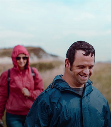  disabled man out for a walk with his carer in the countryside.