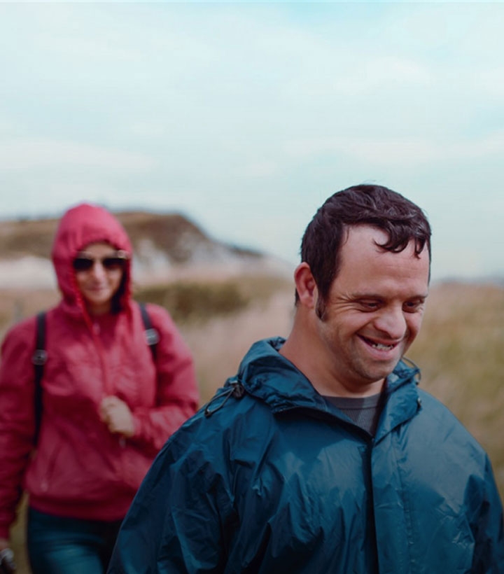 disabled man out for a walk with his carer in the countryside.