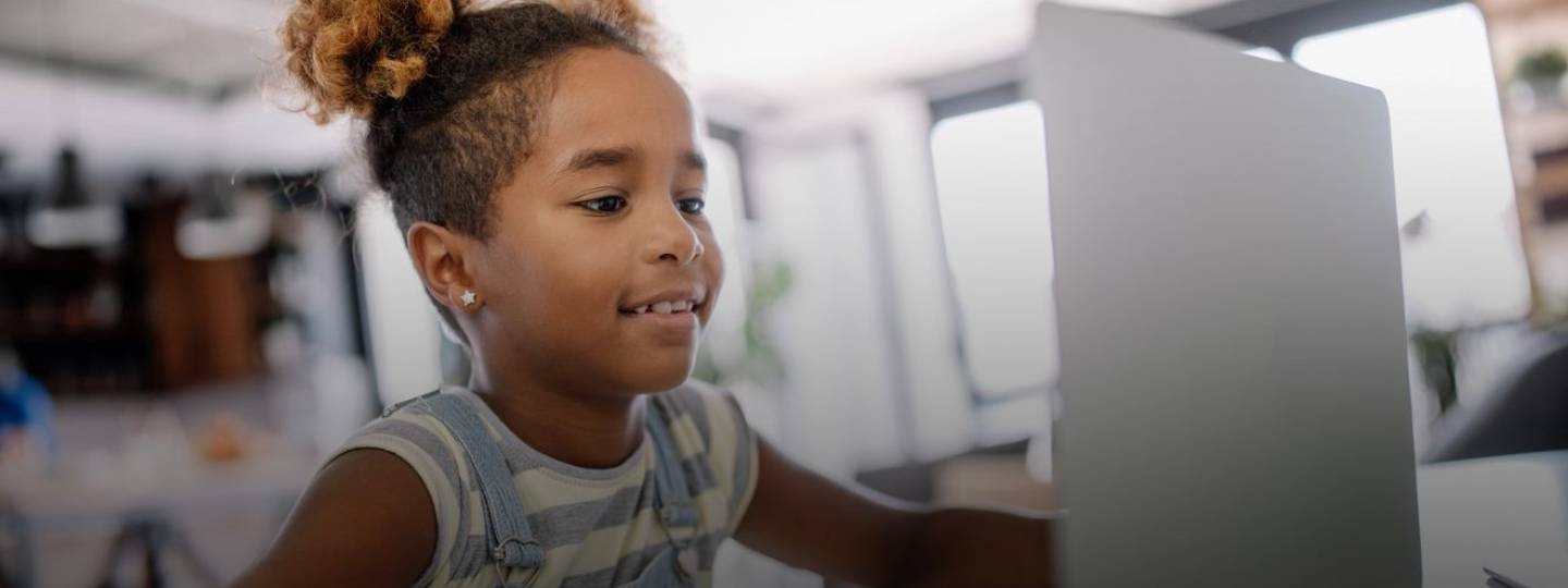 young girl smiling at computer