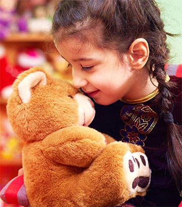 little girl cuddling her teddy bear