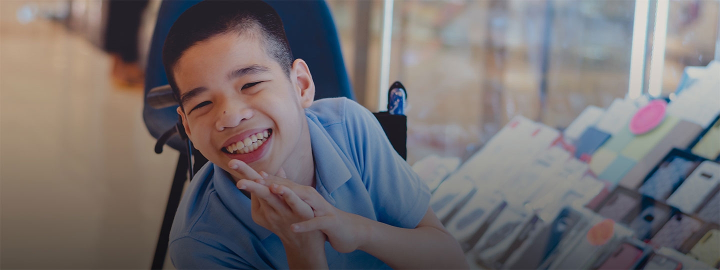 young boy in wheelchair smiling