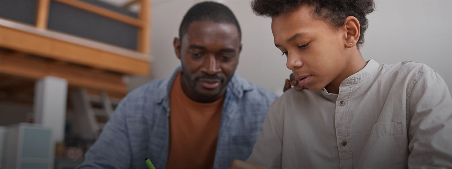 Man helping a boy with his studies
