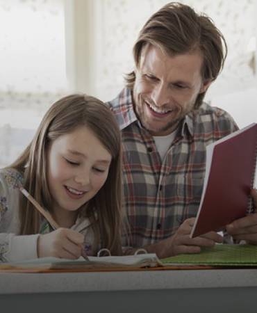 father helping daughter do homework