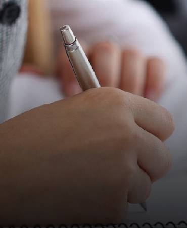 a hand holding a pen writing.
