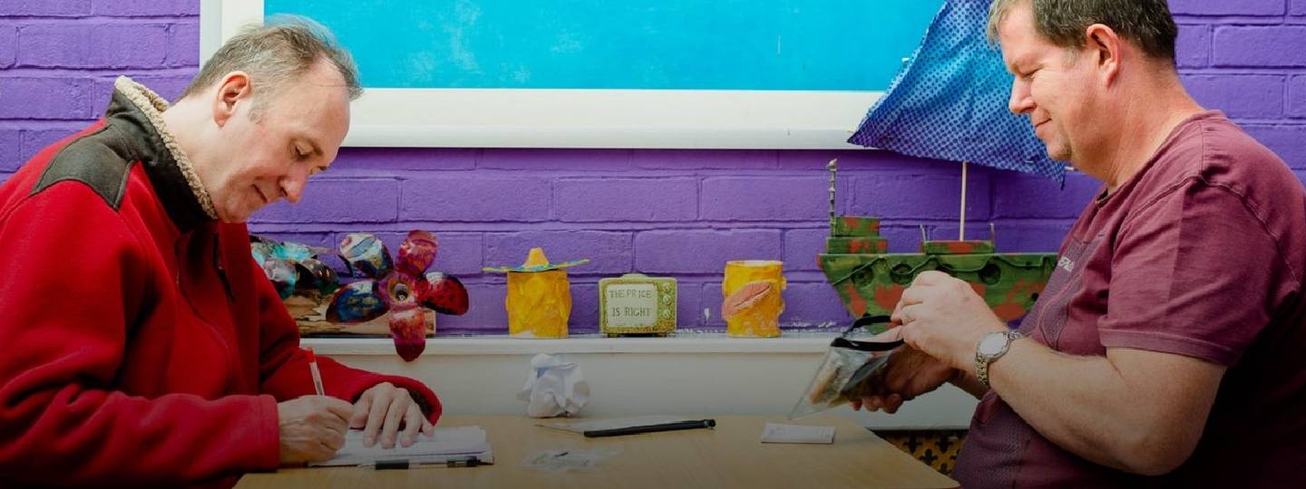 man and carer working at a table.